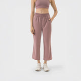 Mujer usando pantalón deportivo rosa terracota estilo cropped con cintura elástica y bolsillos, ideal para yoga o uso casual.