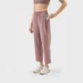 Mujer usando pantalón deportivo rosa terracota estilo cropped con cintura elástica y bolsillos, ideal para yoga o uso casual.