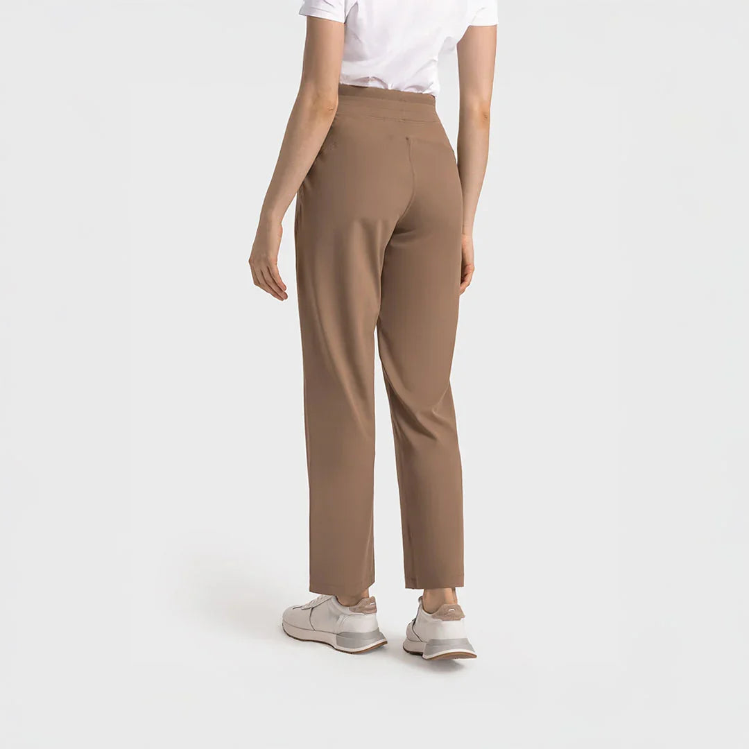 Vista posterior de mujer con pantalón deportivo verde menta de pierna recta y pretina ancha, estilo athleisure.