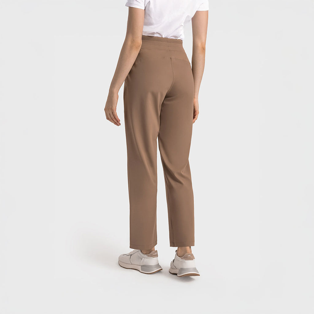 Vista posterior de mujer con pantalón deportivo verde menta de pierna recta y pretina ancha, estilo athleisure.