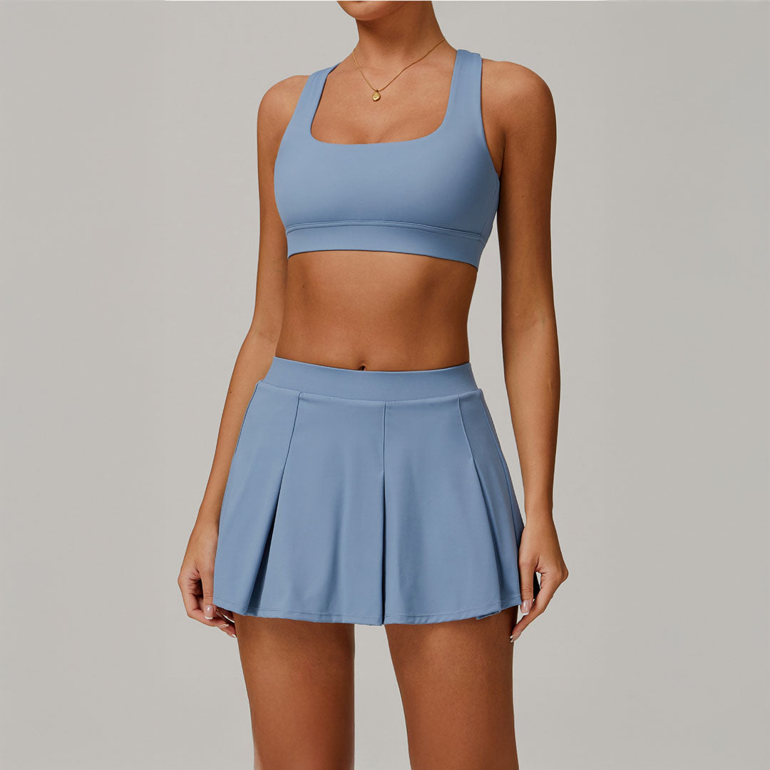 Mujer luciendo un conjunto deportivo de falda y sports bra celeste 