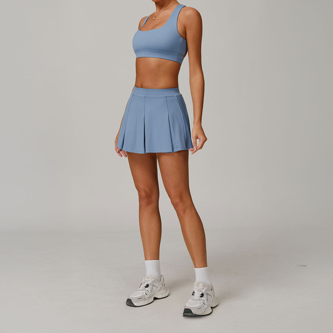 Mujer luciendo un conjunto deportivo de falda y sports bra celeste 