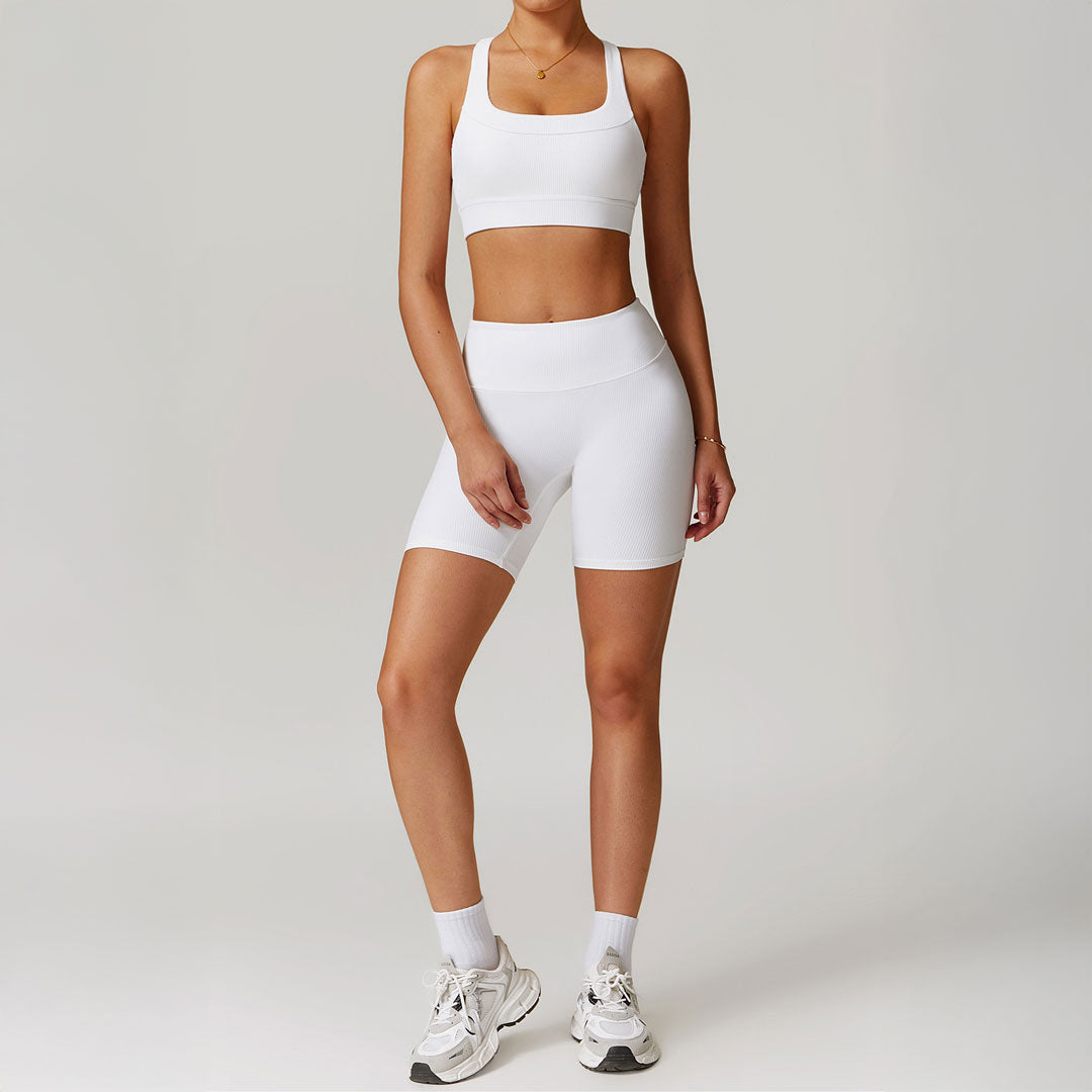 Mujer luciendo un conjunto de short legging y top deportivo blanco