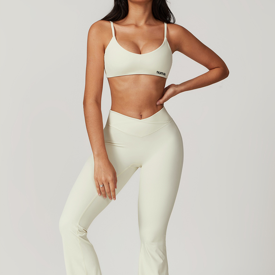 Persona con sports bra beige y legging acampanado beige