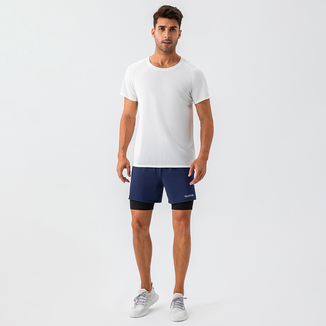 Hombre luciendo short deportivo azul y camisa blanca