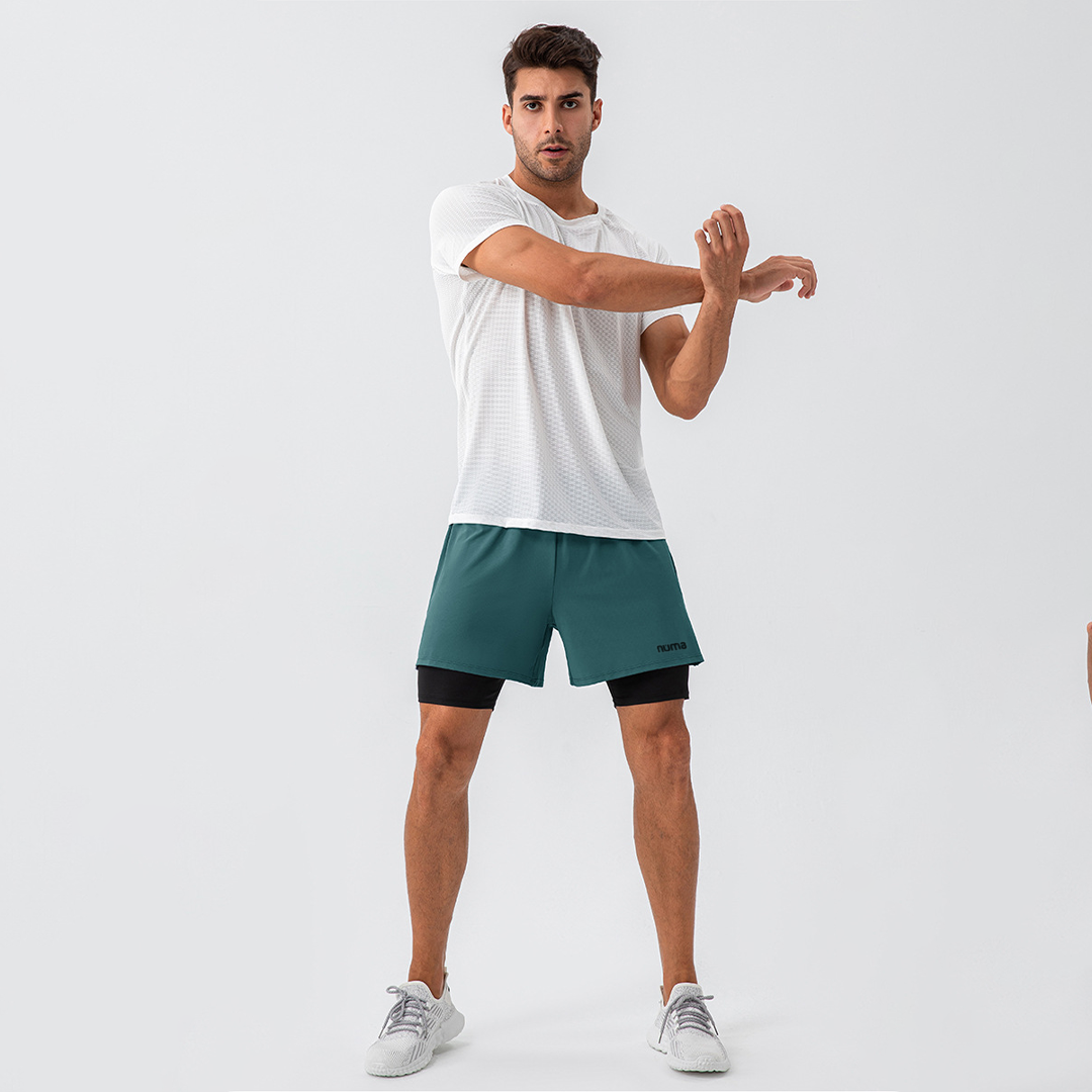 Hombre luciendo short deportivo verde y camisa blanca